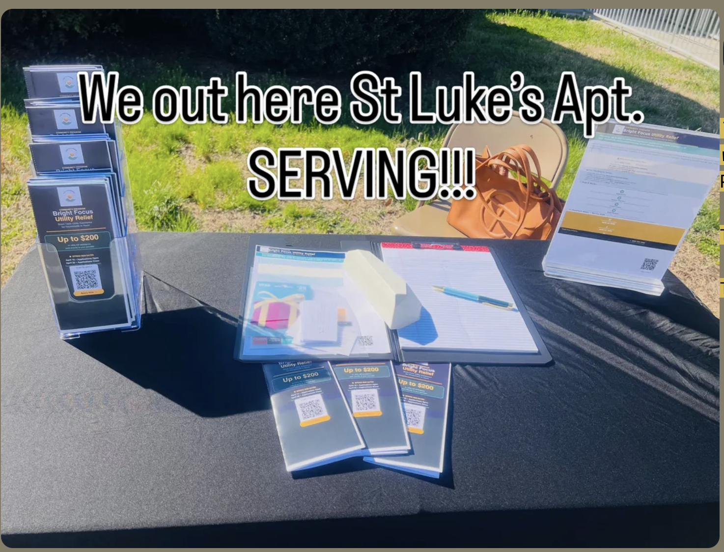 Bright Focus Utility Relief flyers and sign-in sheet on the outreach table at St. Luke's Apartments