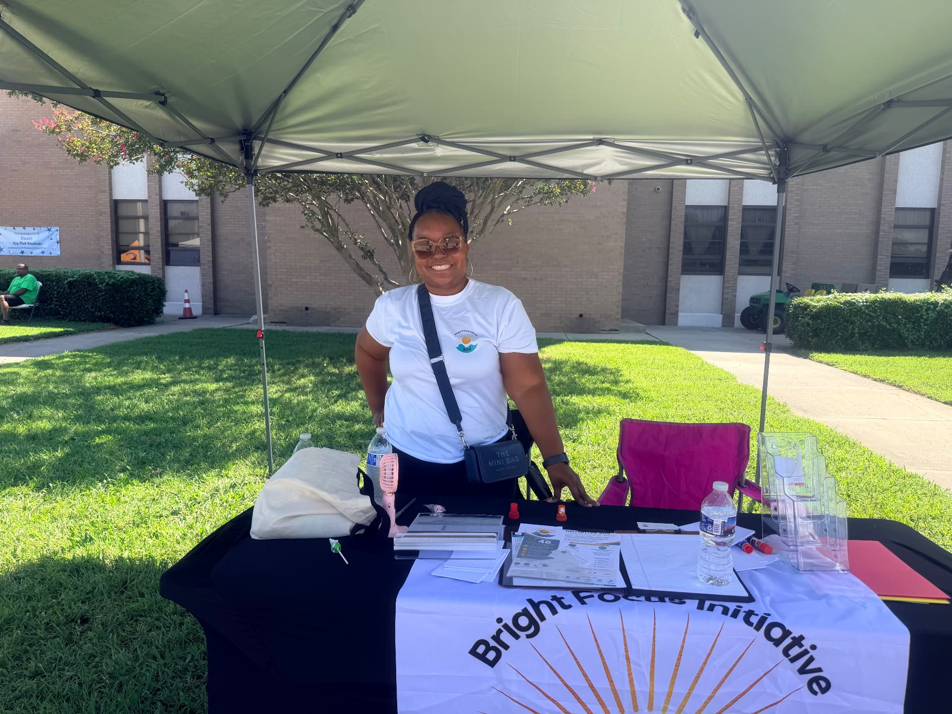 Volunteer in a Bright Focus Initiative shirt standing at the outreach table